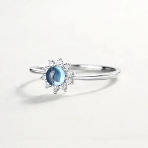 Elegant silver sunflower ring with blue center gemstone and small round diamonds