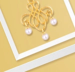 Detalle del colgante de oro de 9K con diseño de filigrana y tres perlas blancas redondas