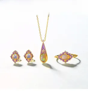 Detail of vintage gold-plated jewelry set with opal stones and purple enamel accents
