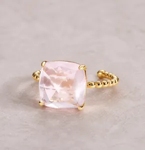 Close-up of square rose-cut pink quartz ring with golden beaded silver band