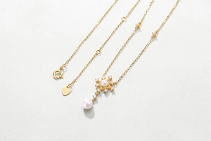 Detail showing S925 sterling silver heart tag and pearl snowflake pendant necklace