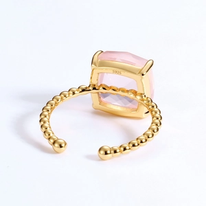 Macro detail showing the S925 silver hallmark and golden beaded band of the pink crystal ring