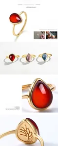 Detail of teardrop garnet gemstone rings with adjustable gold bands and embossed texture