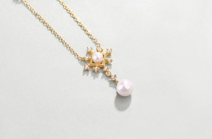 Macro shot of 925 silver pearl necklace pendant with glittering starburst details