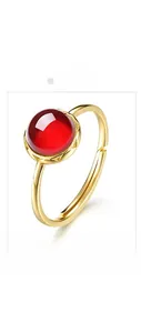 Detailed close-up of a 925 silver gold-plated ring with a round red garnet gemstone
