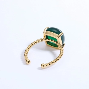 Close-up of S925 sterling silver stamp on gold-plated ring with green gemstone