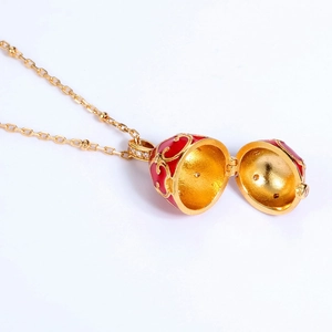 Vista detallada del colgante de huevo estilo Fabergé bañado en oro con esmalte rojo