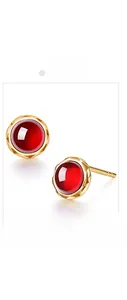 Detailed view of 925 silver gold-plated stud earrings with round red garnet gemstones