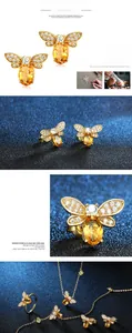 Macro detail of gold-plated bee jewelry set featuring yellow crystal and white zircon pavé wings