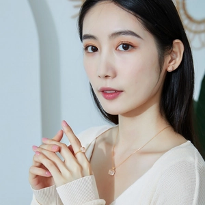 Asian model wearing rose cut pink quartz jewelry set with gold twist ring and necklace