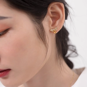 Macro shot of 925 silver bee stud earrings with yellow crystal and zircon wings