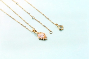 Detail of 9K gold plated silver necklace with geometric pink crystal and spring clasp