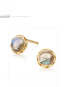 Macro shot of circular natural labradorite gemstone set in a gold-plated silver stud earring
