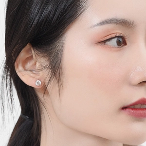 Vue rapprochée d'une boucle d'oreille clou en zircon sur l'oreille d'un modèle