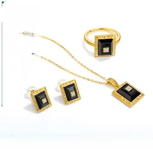 Macro detail of retro jewelry set featuring black agate gems and gold plated wavy edges