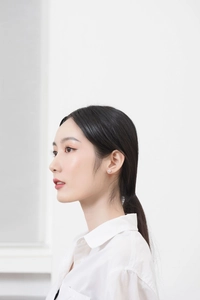 Gros plan d'un clou d'oreille minimaliste en argent 925 avec zircone sur un modèle féminin