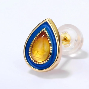 Macro detail of amber droplet earring with blue enamel and gold-plated S925 silver finish