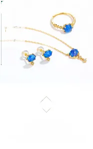 Detailed close-up of blue synthetic opal jewelry set with gold plating and zircons