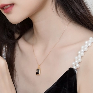 Elegant gold-plated silver necklace with rectangle black agate pendant on female model