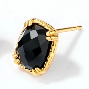 Detail of vintage gold plated earrings featuring a faceted black onyx stone setting