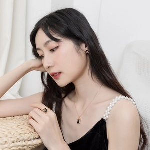 Elegant gold-plated jewelry set with black agate squares worn by model in velvet dress