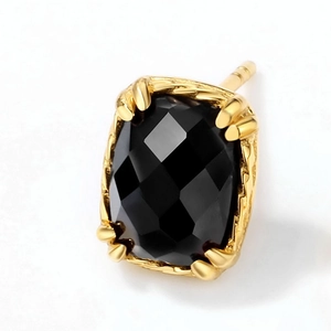 Detailed macro view of black cushion-cut agate earring with gold plated prong setting