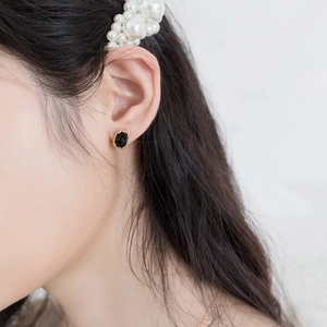 Elegant gold plated silver earrings with black faceted gemstone on model