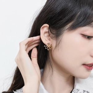 Handcrafted sterling silver lotus earrings with natural moonstone on model's ear