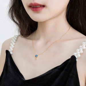 Détail d'un collier élégant en argent S925 doré avec pendentif opale bleue sur un mannequin