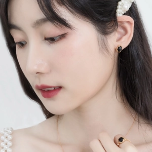 Detail of vintage gold plated earrings and ring set with black faceted agate stones