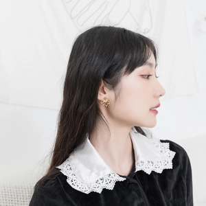 Detailed view of handmade sterling silver lotus earring with grey gemstone on a model