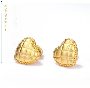 Macro detail of quilted pattern vintage heart stud earrings with matte gold plating