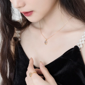 Detailopname van hartvormige labradoriet ketting en ring set bij een elegant model