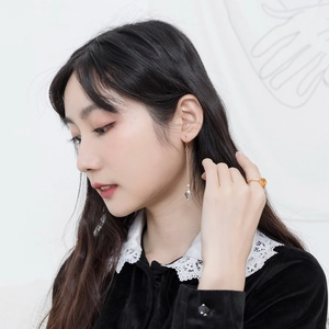 Detail of s925 silver gold-plated ring with round amber gemstone on elegant model