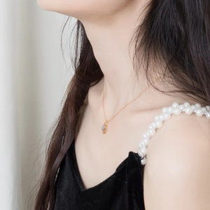 Detail van een 18K vergulde S925 zilveren ketting met labradoriet hanger op een model