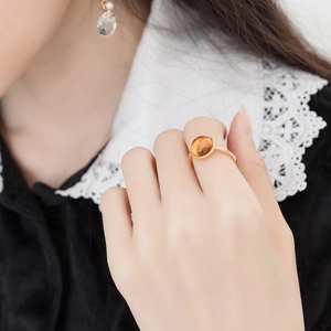 Minimalist S925 silver gold-plated ring with round amber gemstone on woman's hand