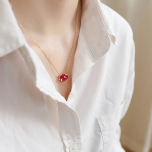 Close-up of geometric sterling silver necklace with pink topaz pendant on model