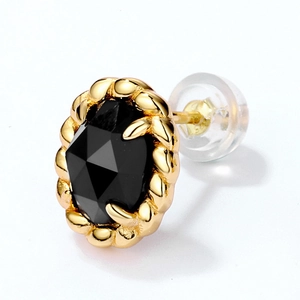 Detail of vintage sterling silver stud earring with black agate and gold rope texture