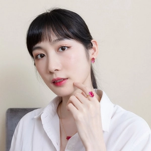 Close-up of pink rectangle cut gemstone jewelry set with gold plated leaf ring on model