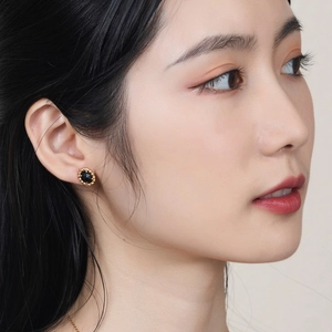Elegant vintage black agate stud earrings with gold rope edge on female model