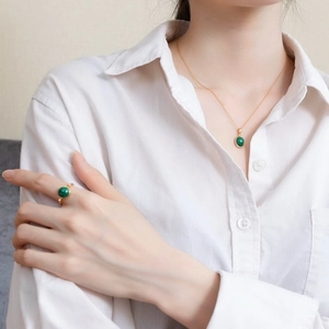 Primo piano del set con ciondolo e anello in malachite vintage in argento 925 dorato