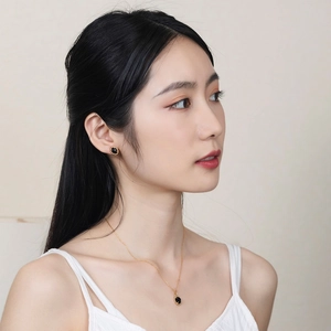 Detail of elegant vintage gold necklace with black onyx pendant and matching stud earrings