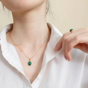 Primo piano del ciondolo in malachite e anello d'oro su set di gioielli in argento 925