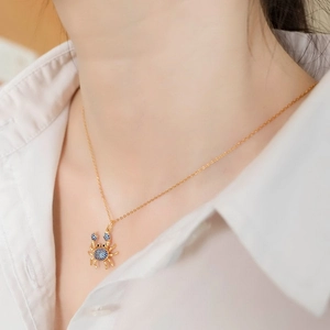 Collier crabe en argent S925 avec cristaux bleus sur chaîne dorée porté par un mannequin