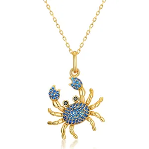 Collier crabe en argent S925 doré avec des pierres de spinelle bleue sur fond blanc