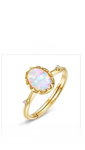 Detail view of oval opal ring with side crystals and gold plated adjustable band