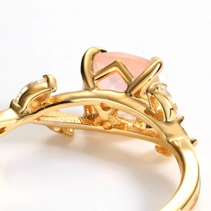 Macro shot of gold leaf-inspired ring with pink gemstone and zircon accents