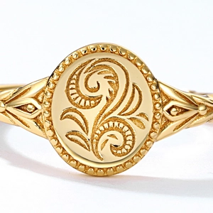 Macro shot of vintage gold-plated leaf signet ring with ornate Victorian scroll patterns