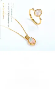 Close-up of vintage oval opal ring and pendant set with gold plated engraved details