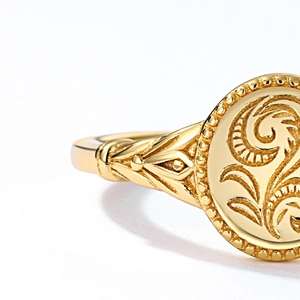 Macro detail of vintage 9K gold leaf ring with intricate scroll patterns and embossed edges